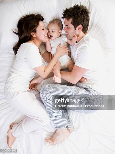 couple and baby in bed - bed on white stock pictures, royalty-free photos & images
