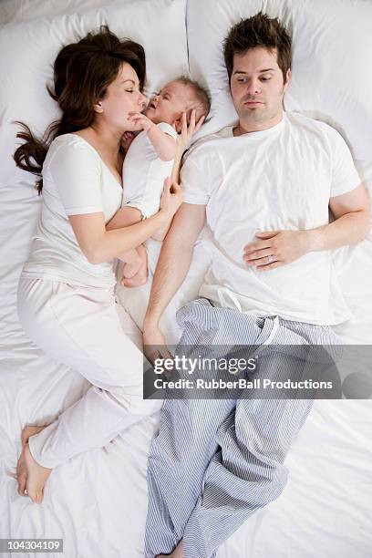 couple and baby in bed - moms crying in bed stock pictures, royalty-free photos & images
