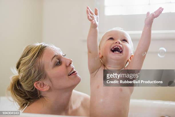 mother and baby taking a bubble bath - bad body language stockfoto's en -beelden