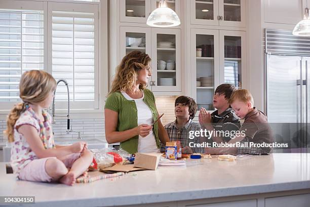 mother and children in the kitchen - fyrbarnsfamilj bildbanksfoton och bilder