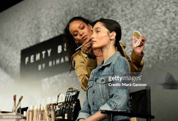Rihanna applies make up on a model during her Fenty Beauty talk in collaboration with Sephora, for the launch of her new Stunna Lip paint "Uninvited"...