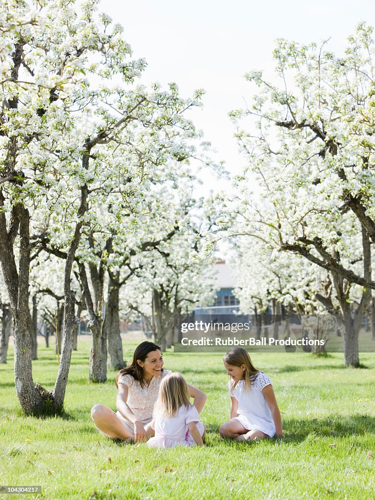 Mother and daughters in a blossoming orchard