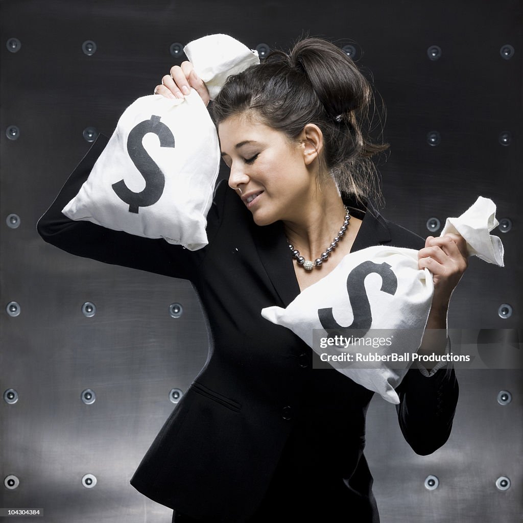 Businesswoman holding two bags of money