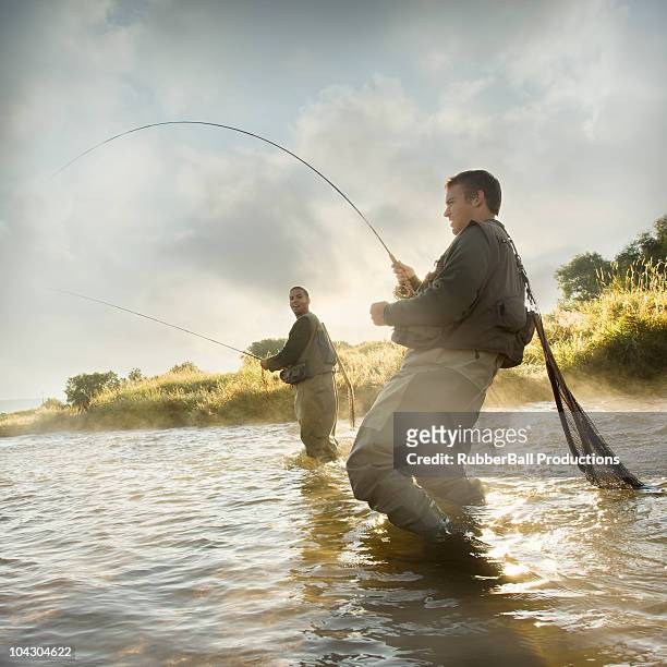 fly fisherman pesca en un río de montaña - casting fotografías e imágenes de stock