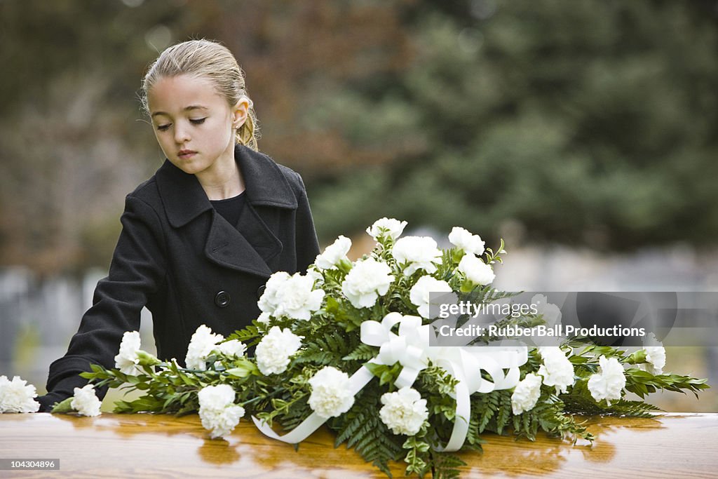 Ragazza in piedi accanto a un Funerale Bara