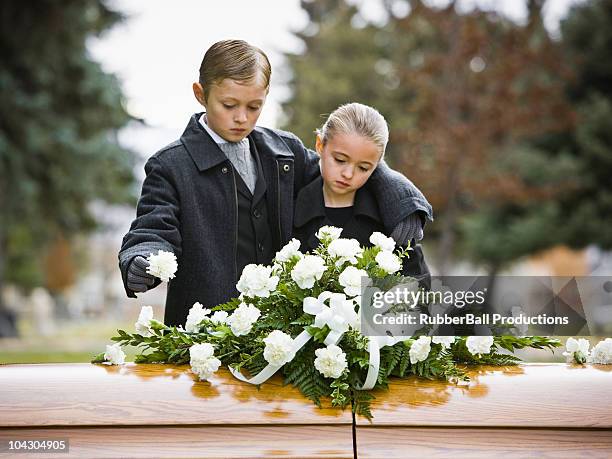 jungen und mädchen in einer trauerfeier anreisen, steht neben den sarg - funeral grief flowers stock-fotos und bilder