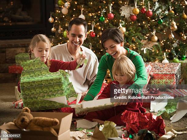 familia navidad presenta apertura - christmas gift fotografías e imágenes de stock