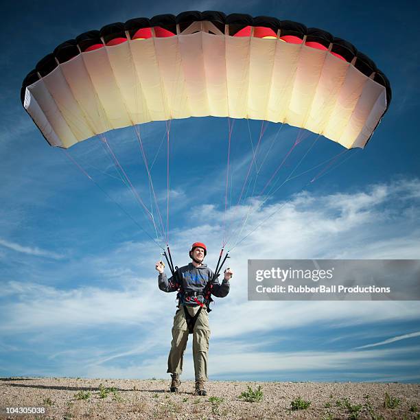 usa, utah, lehi, parachutist masculinos jóvenes de pie en el desierto - bailout fotografías e imágenes de stock