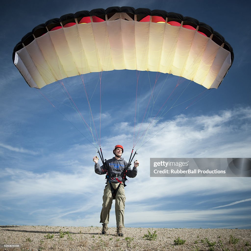 USA,Utah,Lehi,Young male parachutist standing on desert,front view