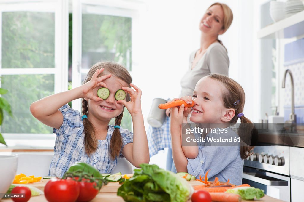 Deutschland, München, Mädchen (4 bis 7) spielt mit Gemüse in der Küche,