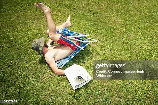 man with newspaper falling off chair - accident stock pictures, royalty-free photos & images