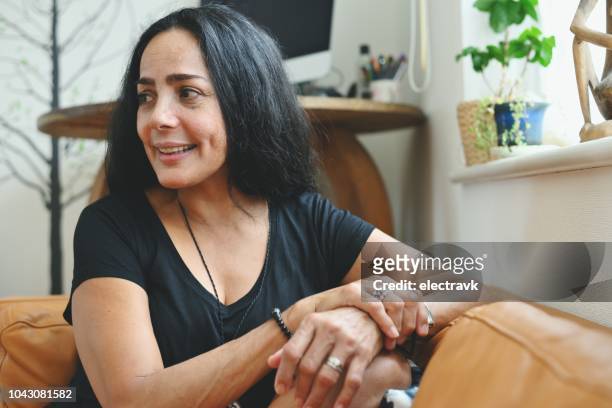 portrait of mature woman sitting at home - puerto rican woman stock pictures, royalty-free photos & images