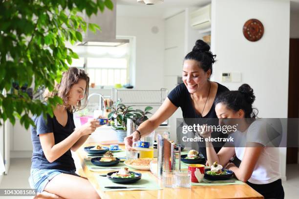 sunday brunch at the family home - mother and two children feeling good common stockfoto's en -beelden