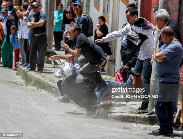 Participant crashes his cart against a race observer during the Formula 1 homemade carts festival at Perseverancia neighbourhood in Bogota, Colombia...