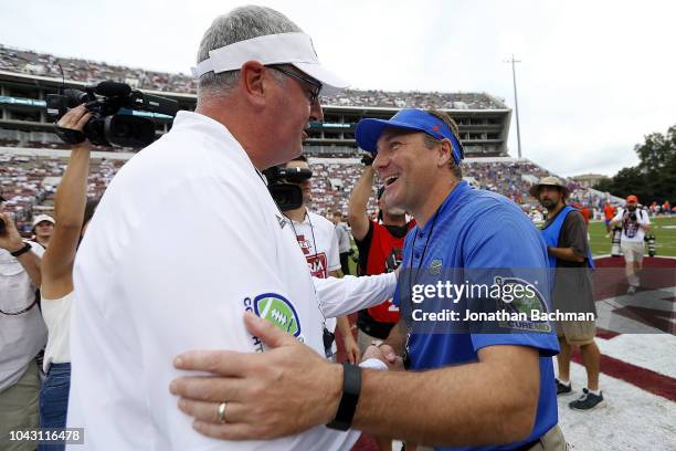 Head coach Joe Moorhead of the Mississippi State Bulldogs and head coach Dan Mullen of the Florida Gators greet each other before a game at Davis...