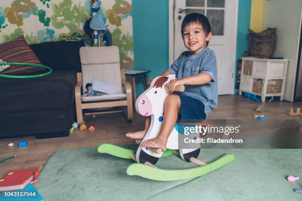 niño montar a caballo mecedora madera - kids mess carpet fotografías e imágenes de stock