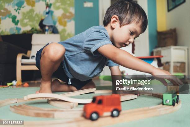 cute little boy playing with wooden train - miniature train stock pictures, royalty-free photos & images