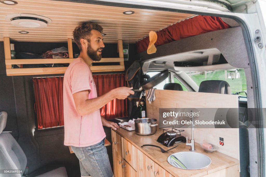 Man cooking pancakes in camper van