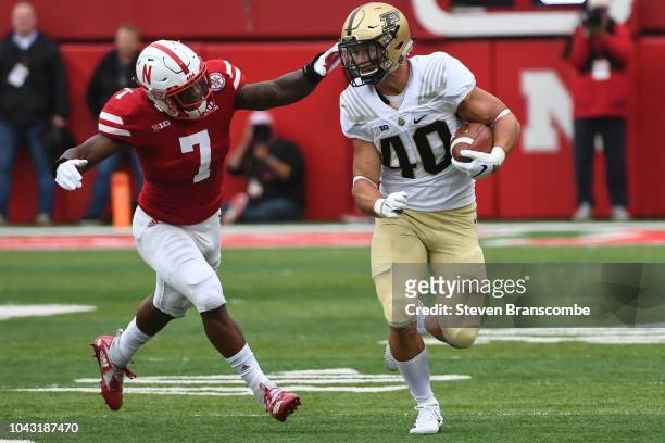 Running back Alexander Horvath of the Purdue Boilermakers runs from linebacker Mohamed Barry of the Nebraska Cornhuskers in the first half at...