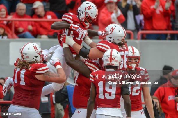 Offensive lineman Boe Wilson of the Nebraska Cornhuskers lifts wide receiver JD Spielman after a touchdown against the Purdue Boilermakers at...