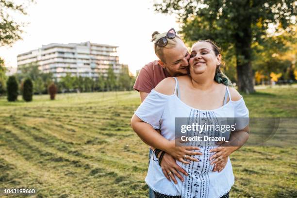 cheerful overweight couple expressing romance in nature - fat couple stock pictures, royalty-free photos & images