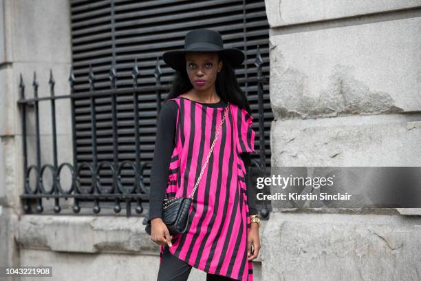 Diane Umuhoza wears Gianco Handmade outfit and Liu Jo bag during London Fashion Week September 2018 on September 14, 2018 in London, England.