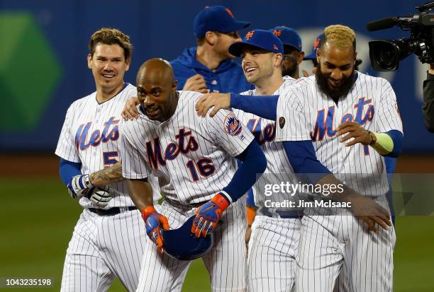 Austin Jackson of the New York Mets celebrates his thirteenth inning game winning double against the Miami Marlins with teammates Jose Lobaton, David...