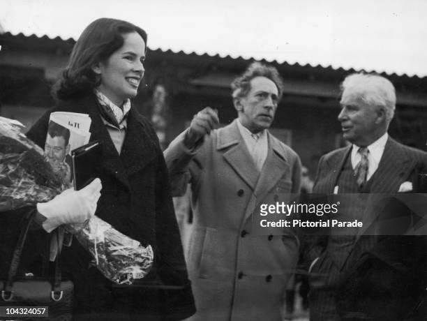 Comic actor Charlie Chaplin and his wife Oona O'Neill are met at Nice Airport, France by French writer and filmmaker Jean Cocteau , 8th March 1953.