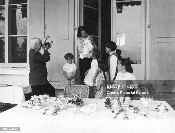 Comic actor Charlie Chaplin films his wife Oona O'Neill as she holds their newborn daughter Jane, at their home, the Manoir de Ban, Switzerland, May...