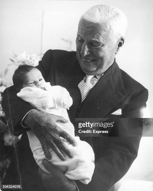Comic actor Charlie Chaplin holding his week-old son Christopher at the Mont-Choisi Clinic, Lausanne, Switzerland, 14th July 1962. Christopher is his...