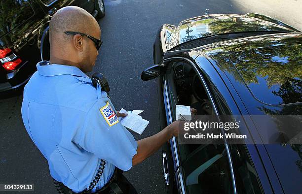 Metropolitan Police Officer Tyrone Gross, hands out a warning to motorist who was talking on his cell phone on September 21, 2010 in Washington, DC....