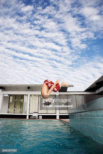 boy (7-9) jumping into pool, side view - daredevil stock pictures, royalty-free photos & images