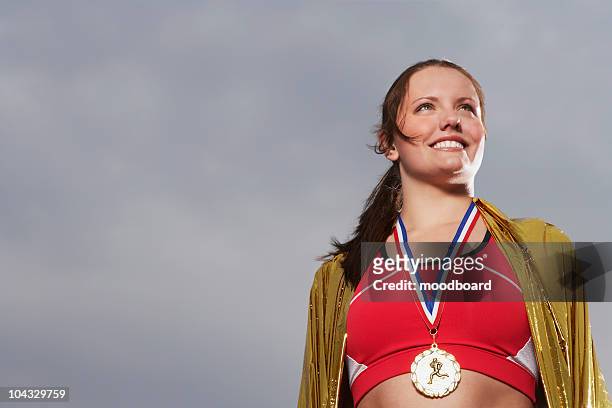 female athlete wearing gold medal, low angle view, portrait - sportsperson medal stock pictures, royalty-free photos & images