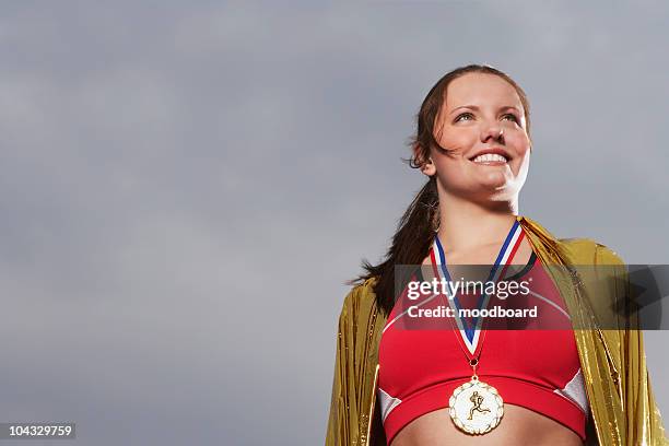 female athlete wearing gold medal, low angle view, portrait - medallist stock pictures, royalty-free photos & images
