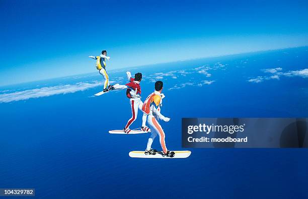 three people skyboarding against blue sky - blue sky friends photos et images de collection