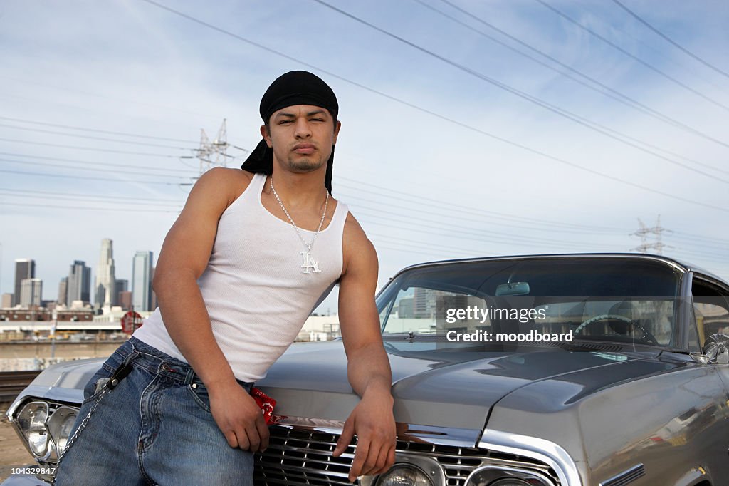 Portrait of man leaning on car