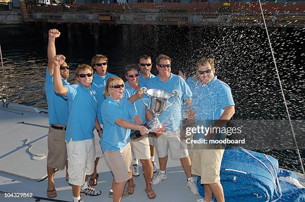 sailing team celebrating with trophy on boat - sailor arm stock-fotos und bilder