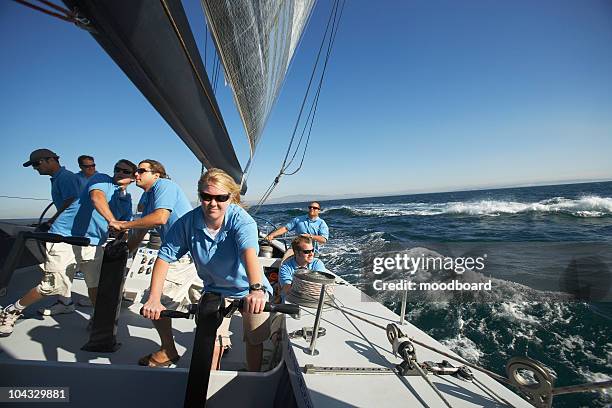 sailing team on yacht - blue sailboat stock pictures, royalty-free photos & images