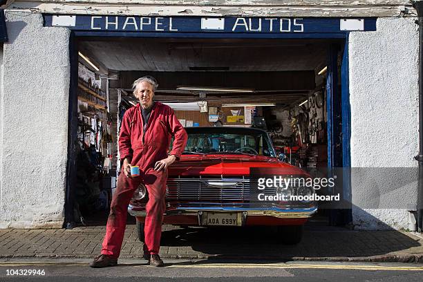 auto mechanic with restored 1961 chevrolet impala - old car stock-fotos und bilder