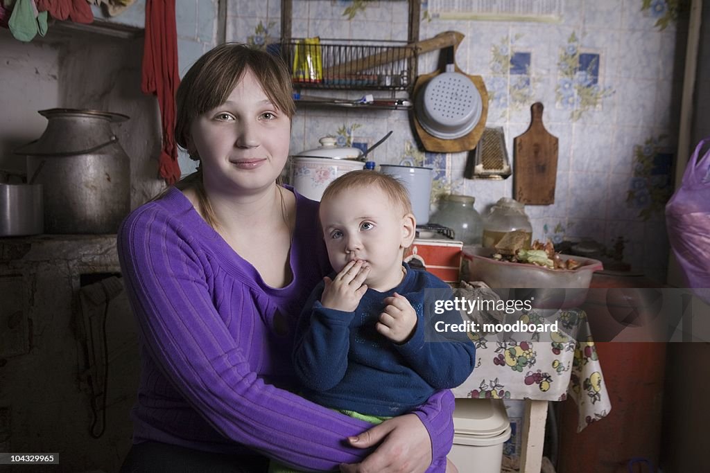 Giovane Madre e figlio sedersi in cucina interni