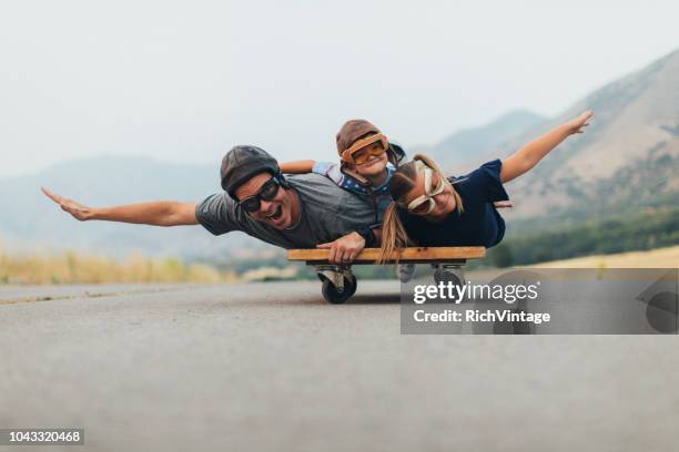 jeunes enfants et papa vole sur un chariot de presse - flying goggles stock photos et images de collection