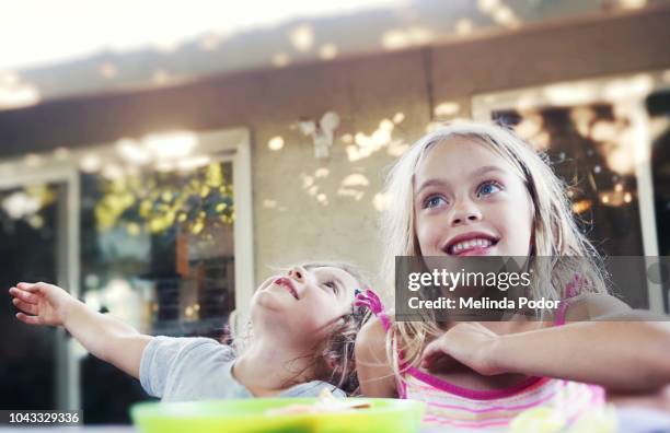 two children enjoying a snack in the back yard - play date stock pictures, royalty-free photos & images