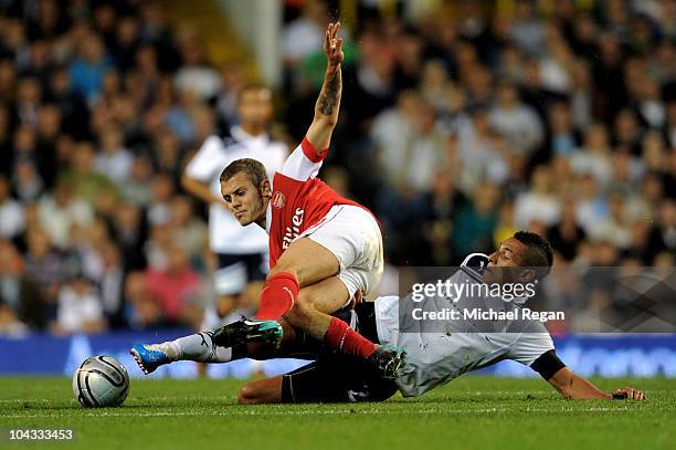 Jack Wilshere of Arsenal is tackled by Jake Livermore of Spurs during the Carling Cup third round match between Tottenham Hotspur and Arsenal at...