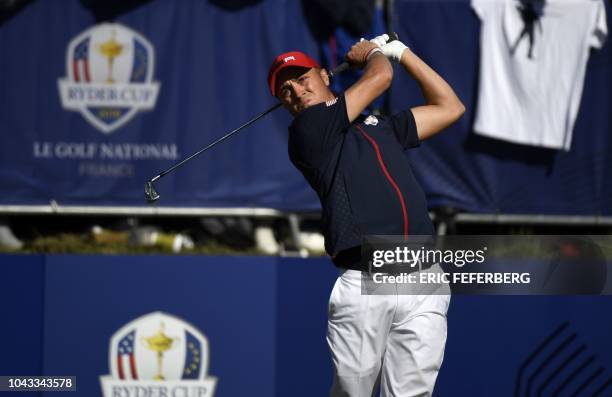 Golfer Justin Thomas plays a tee shot during his singles match with Europe's Northern Irish golfer Rory McIlroy on the third day of the 42nd Ryder...