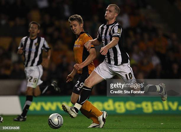 Wolves goalscorer Kevin Doyle shrugs off the challenge of Neal Bishop during the Carling Cup 3rd Round match between Wolverhampton Wanderers and...