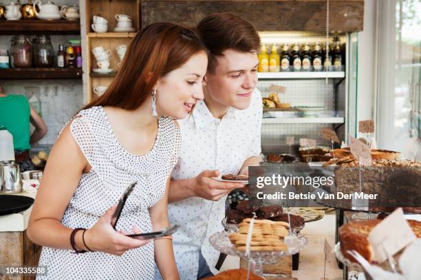 couple choosing cake in cake shop. - couple choosing stock pictures, royalty-free photos & images