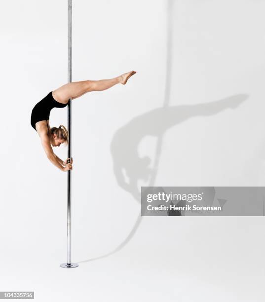 gymnast holding herself up on a pole - gymnaste photos et images de collection