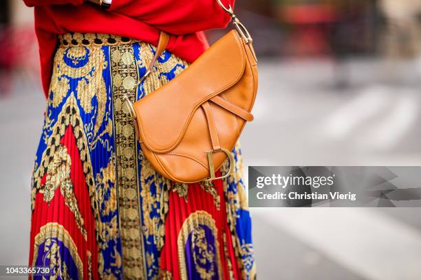 Alexandra Lapp is seen wearing a pleated printed midi skirt from Versace, a long red cashmere turtle neck pullover from Falconeri, a vintage Dior...