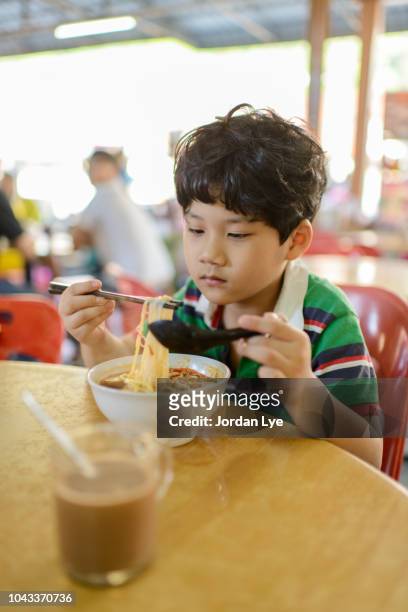 asia boy eating penang famous hokkien mee - hokkien mee stock pictures, royalty-free photos & images