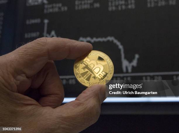 Symbol photo on the topics digital curreny, cryptocurrency, currency speculation, stock market, etc. The picture shows a Bitcoin in front of the...